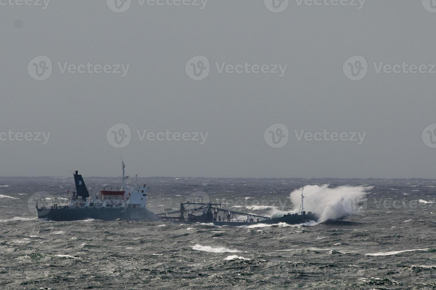 A ship seems to sink in the big waves of the arctic ocean tempest photo