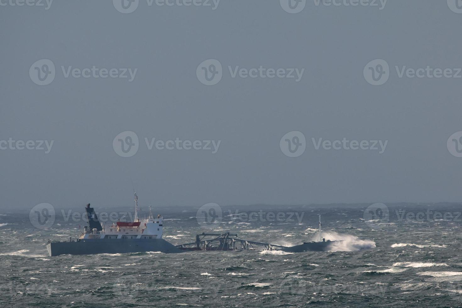 A ship seems to sink in the big waves of the arctic ocean tempest photo