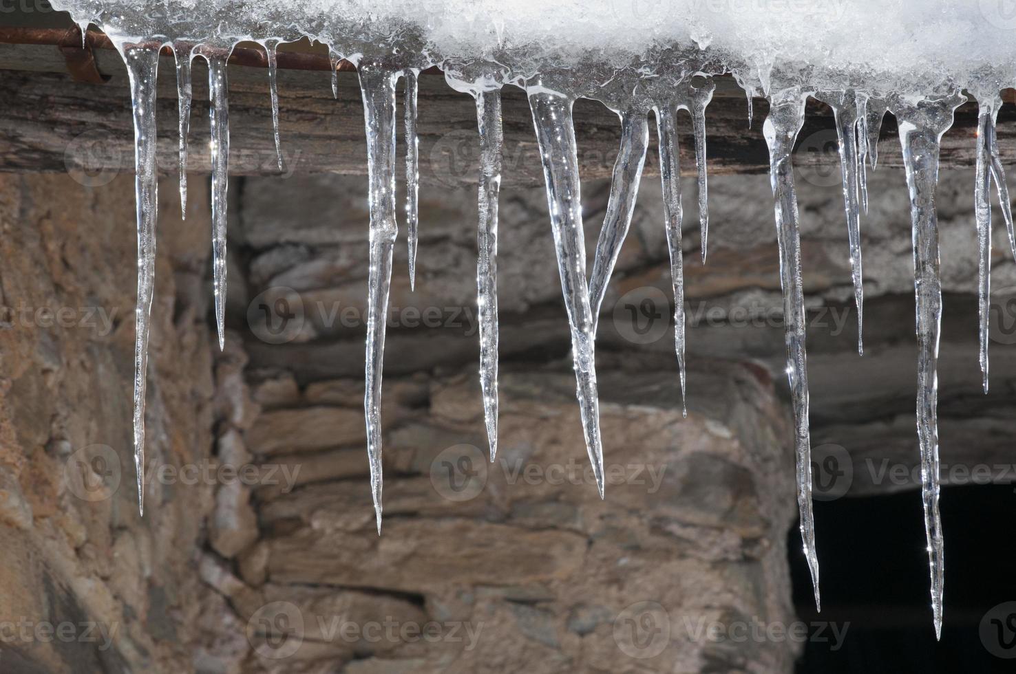 icicles on stone wall photo