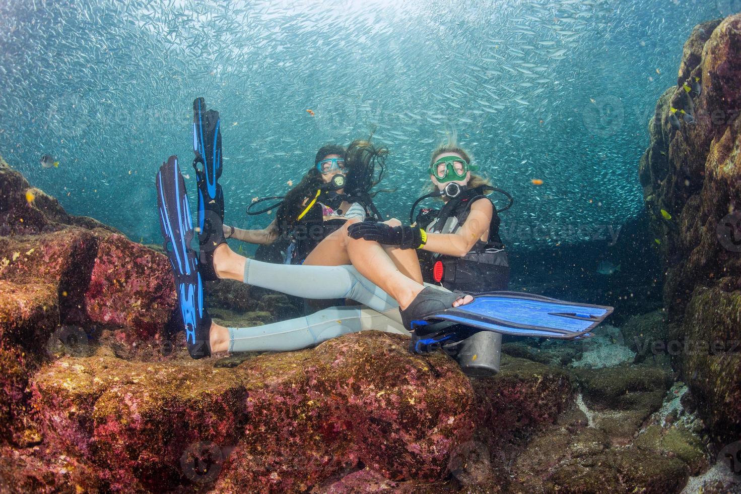 beautiful girls looking at you while swimming underwater photo