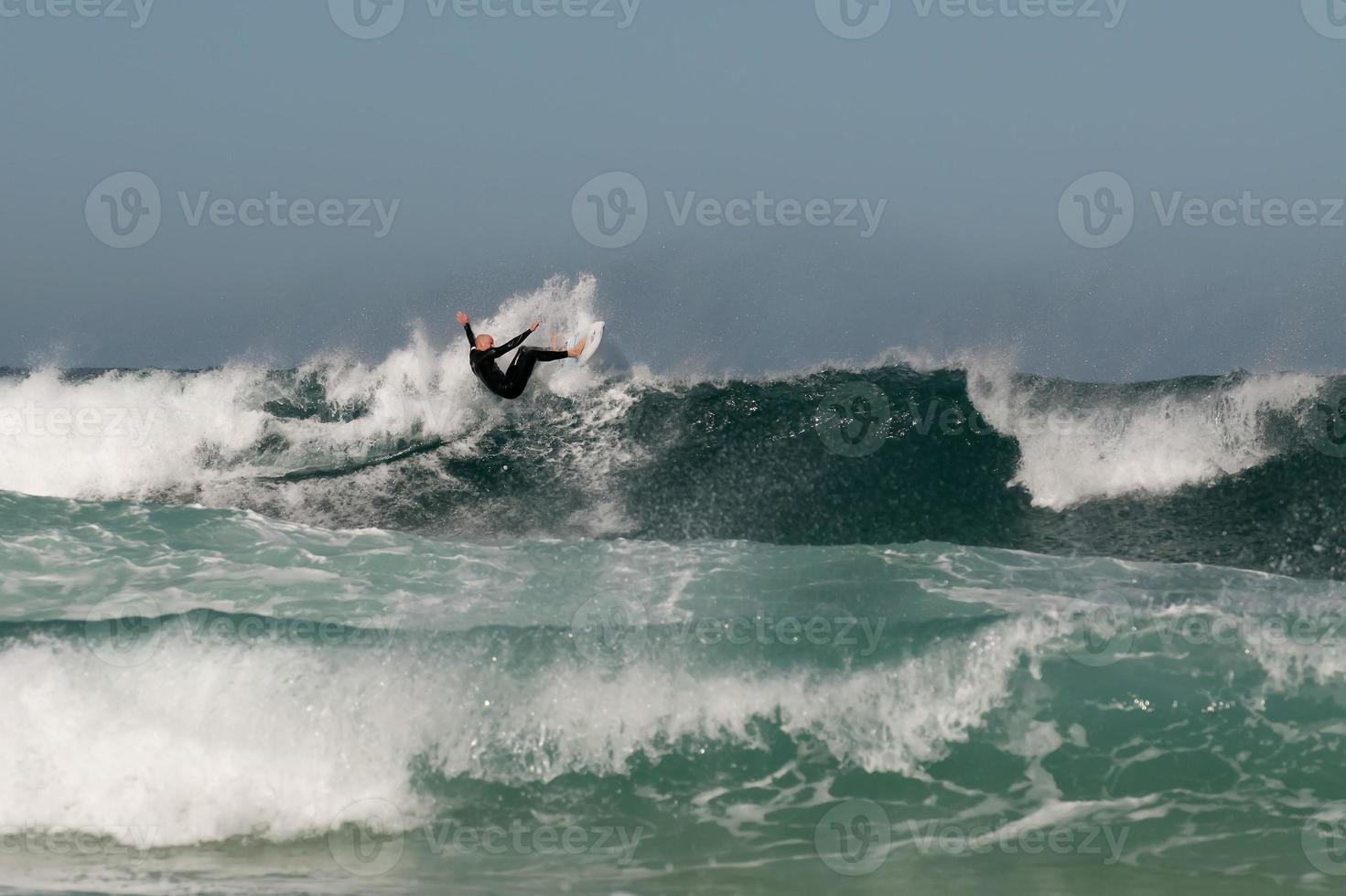 An isolated surfer jumping on big waves photo