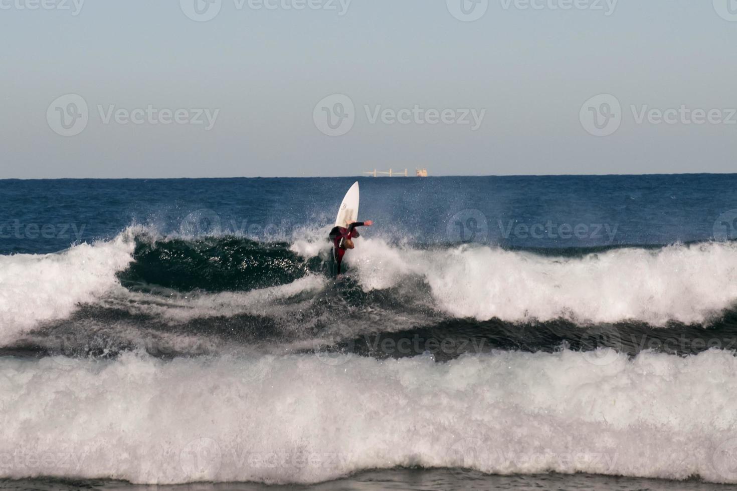 An isolated surfer jumping on big waves riding like a pro photo