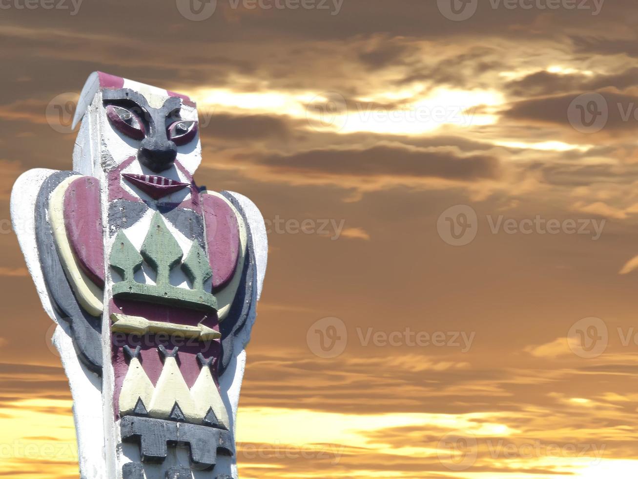 A totem wood pole in the gold cloudy background photo