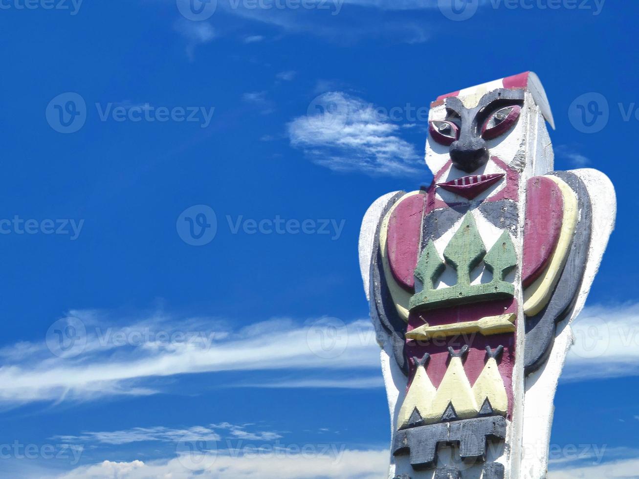 A totem wood pole in the blue cloudy background photo