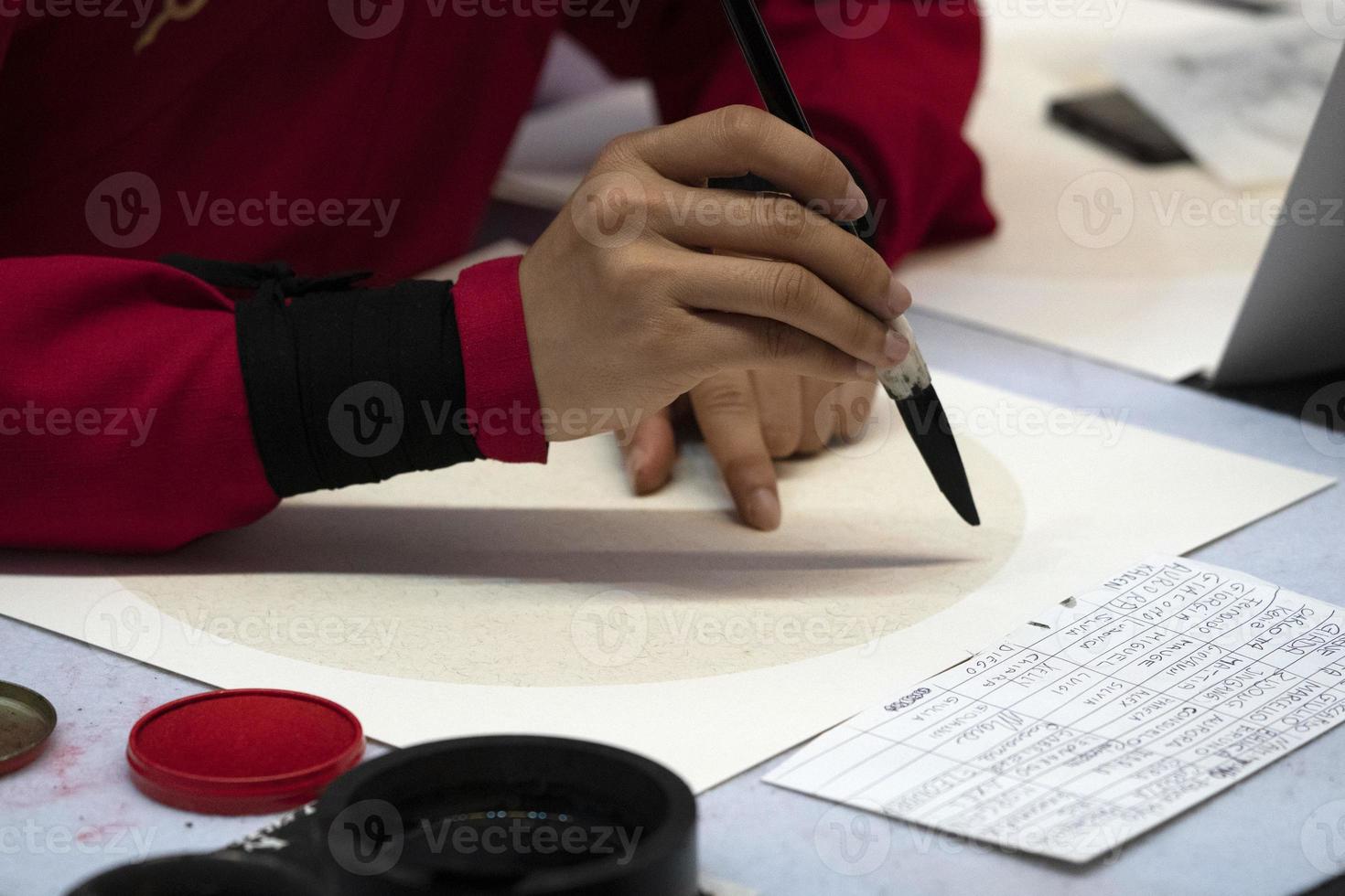 japanese woman writing ideograms with brush photo