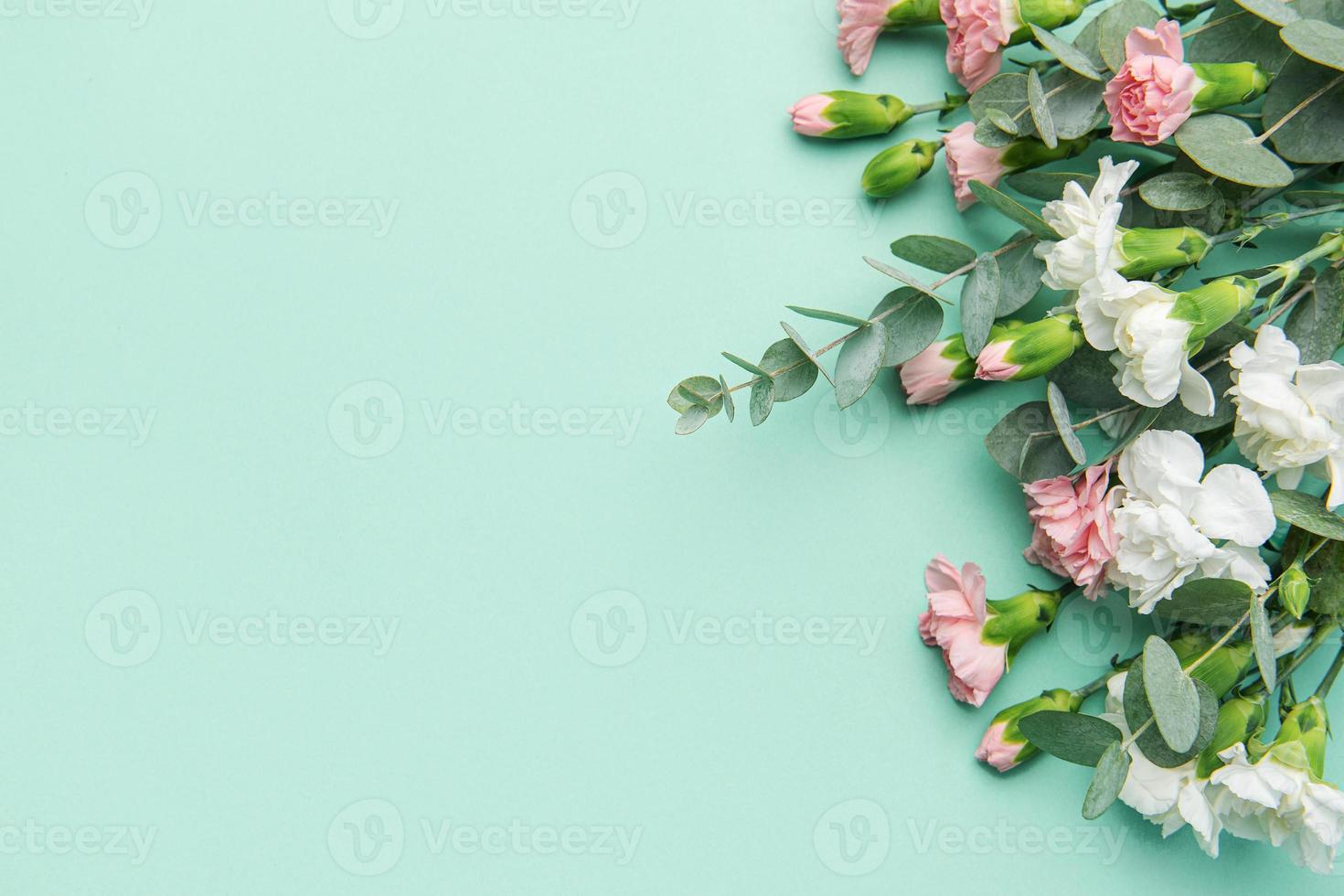 un ramo de flores de blanco y rosado claveles con eucalipto ramas en un suave verde antecedentes. foto