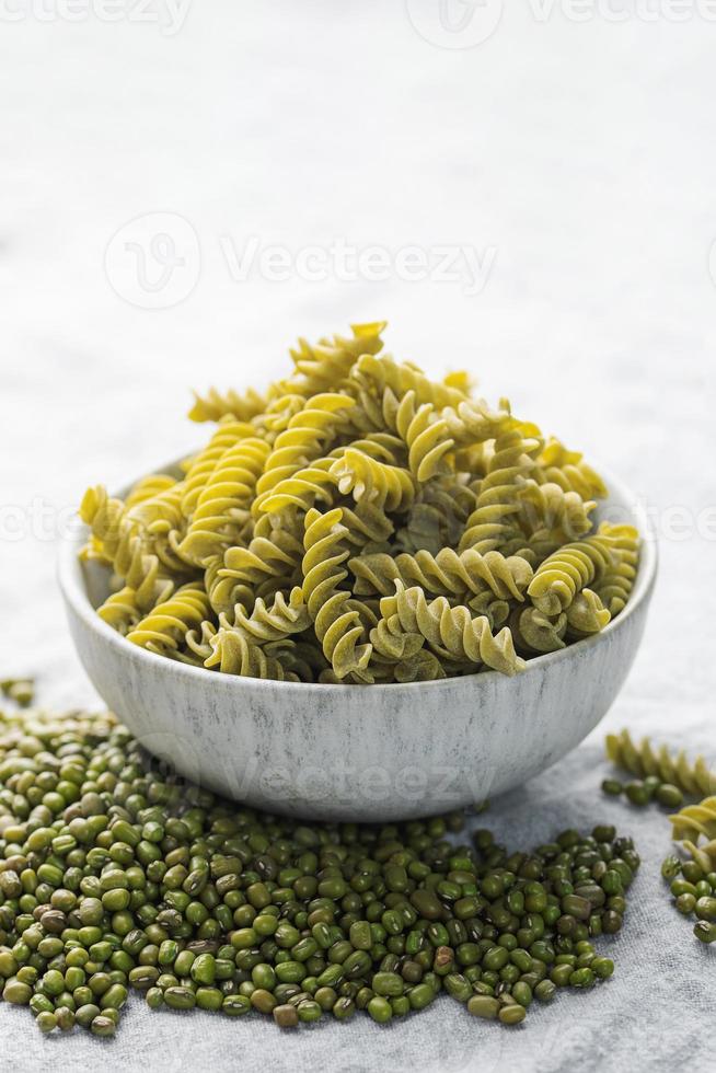 pasta fusilli de frijol mungo sobre un fondo textil gris. foto