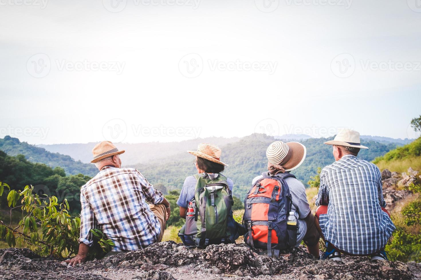 A group of Asian seniors hiking and standing on high mountains enjoying nature. Senior community concepts photo