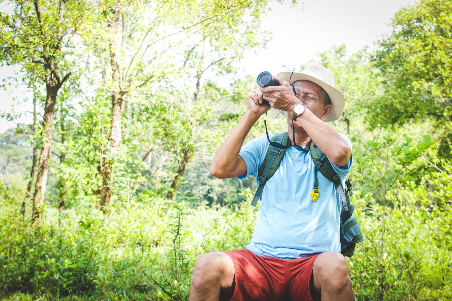 Elderly Asian Men Travel Nature He happily photographed the wildlife. The concept of a senior retirement community photo