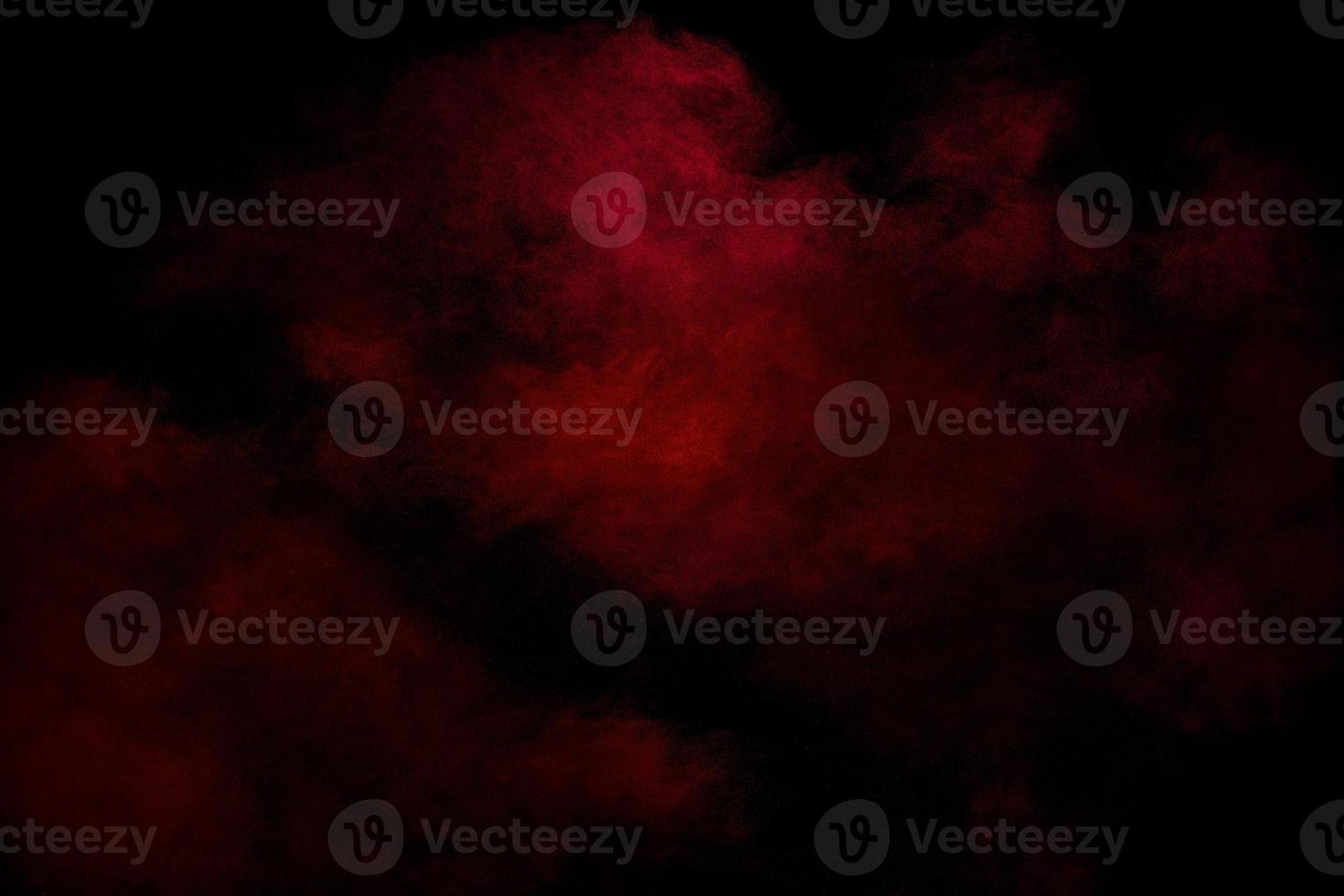 Red powder explosion cloud on black background. Freeze motion of red color dust . photo