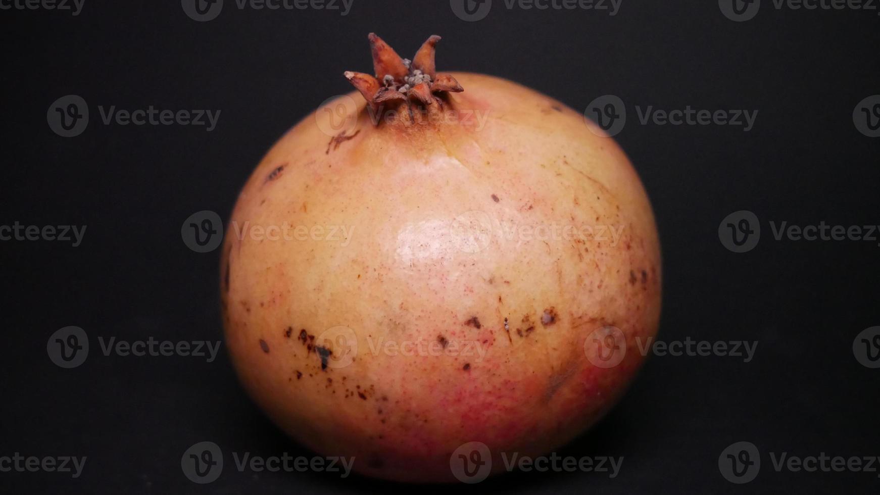 Ripe pomegranate   on  a black background photo