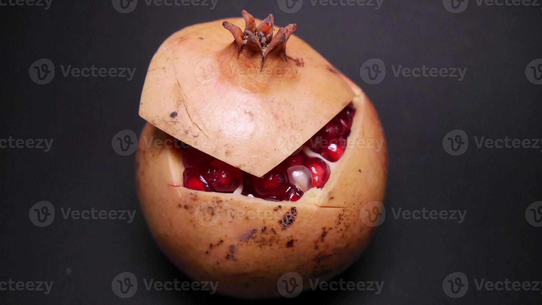 Ripe pomegranate   on  a black background photo
