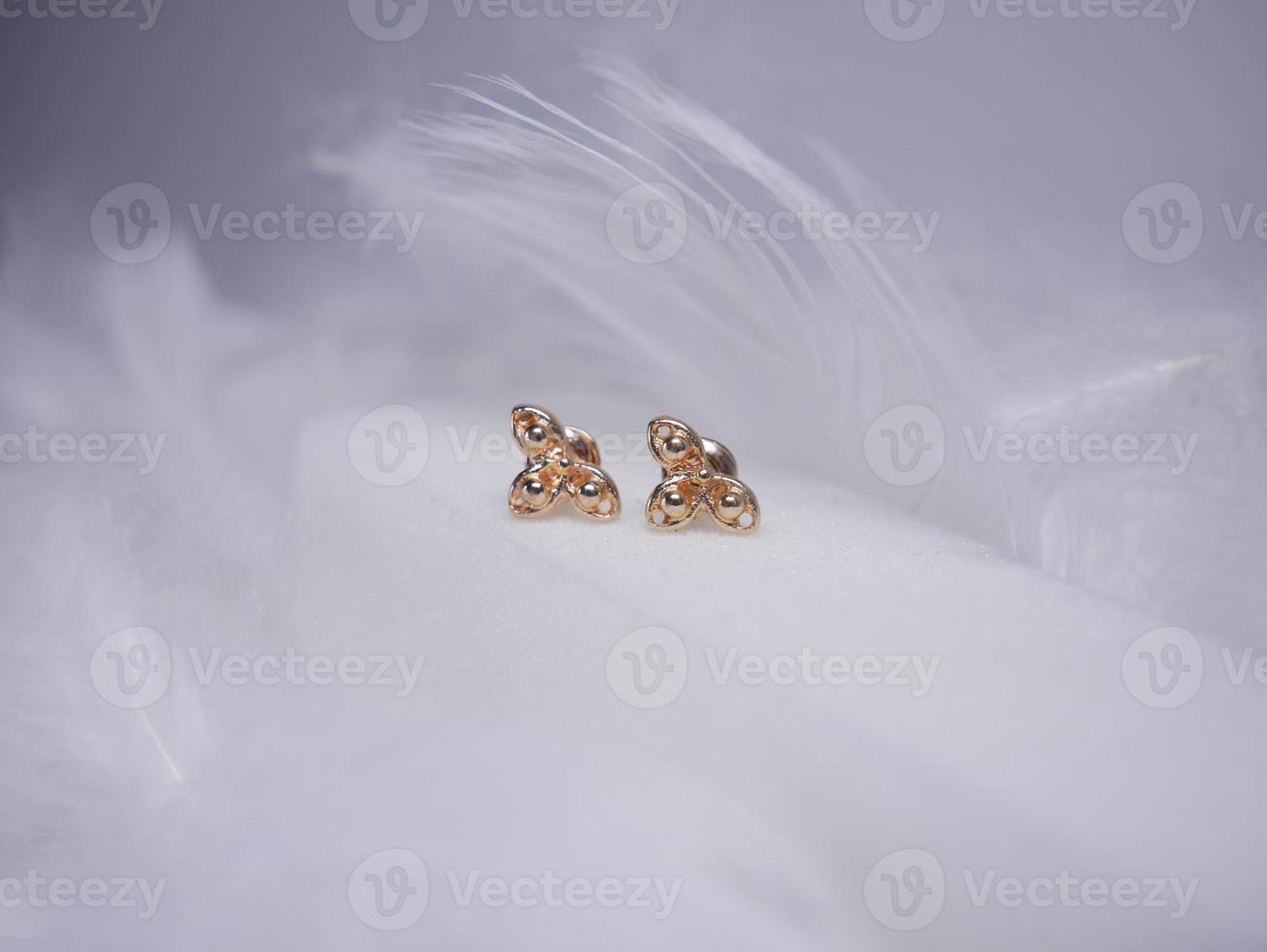 Beautiful gold earrings close-up on a white background photo