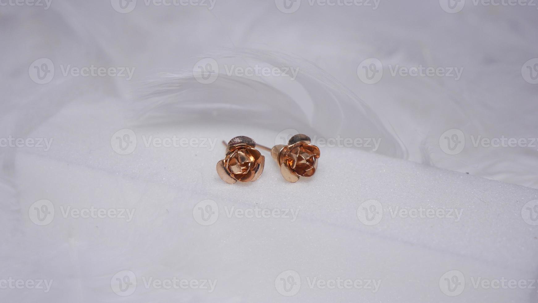 Beautiful gold earrings close-up on a white background photo