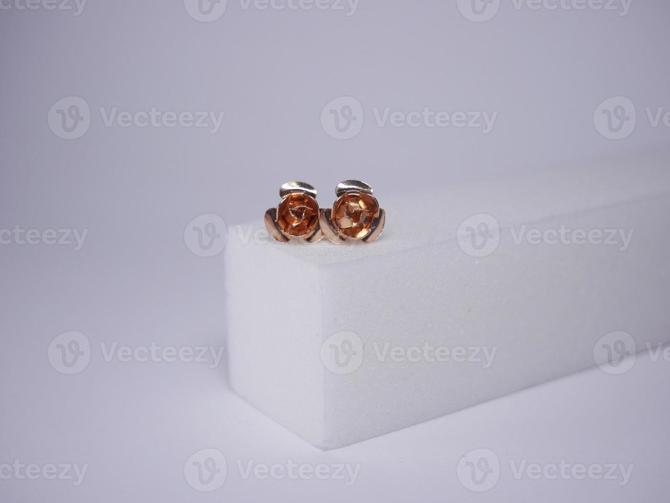 Beautiful gold earrings close-up on a white background photo