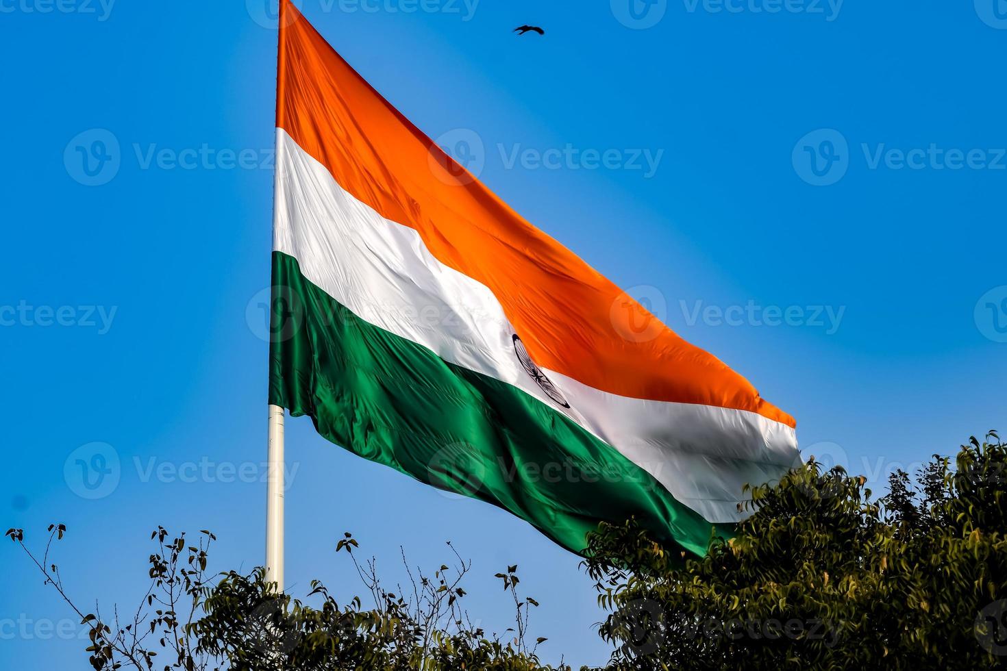 India flag flying high at Connaught Place with pride in blue sky, India flag fluttering, Indian Flag on Independence Day and Republic Day of India, tilt up shot, Waving Indian flag, Har Ghar Tiranga photo