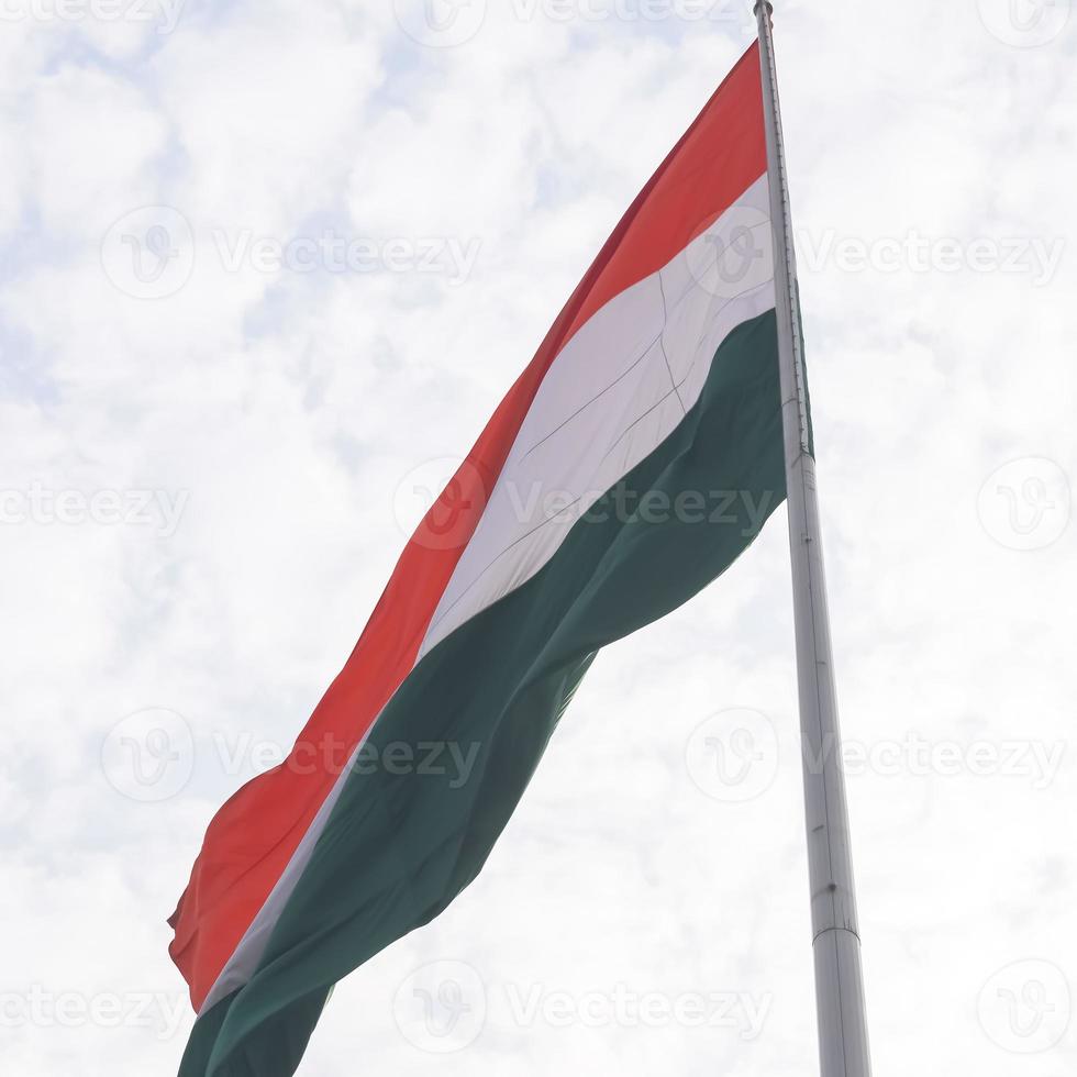 India flag flying high at Connaught Place with pride in blue sky, India flag fluttering, Indian Flag on Independence Day and Republic Day of India, tilt up shot, Waving Indian flag, Har Ghar Tiranga photo