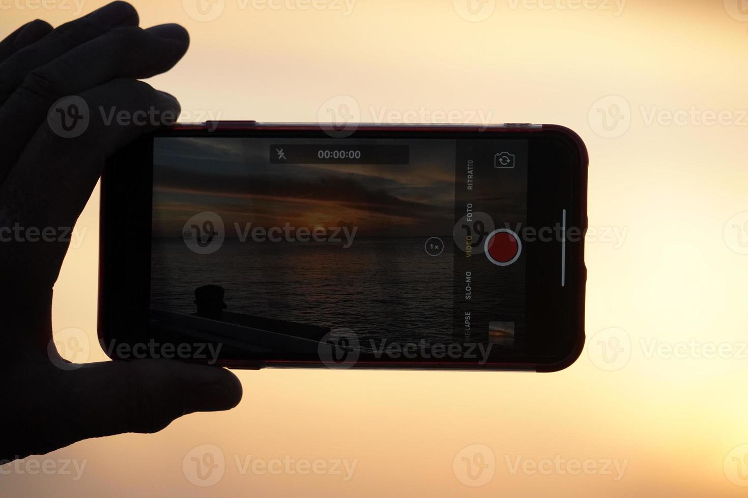 Hands taking selfie with smartphone at sunset in key west photo