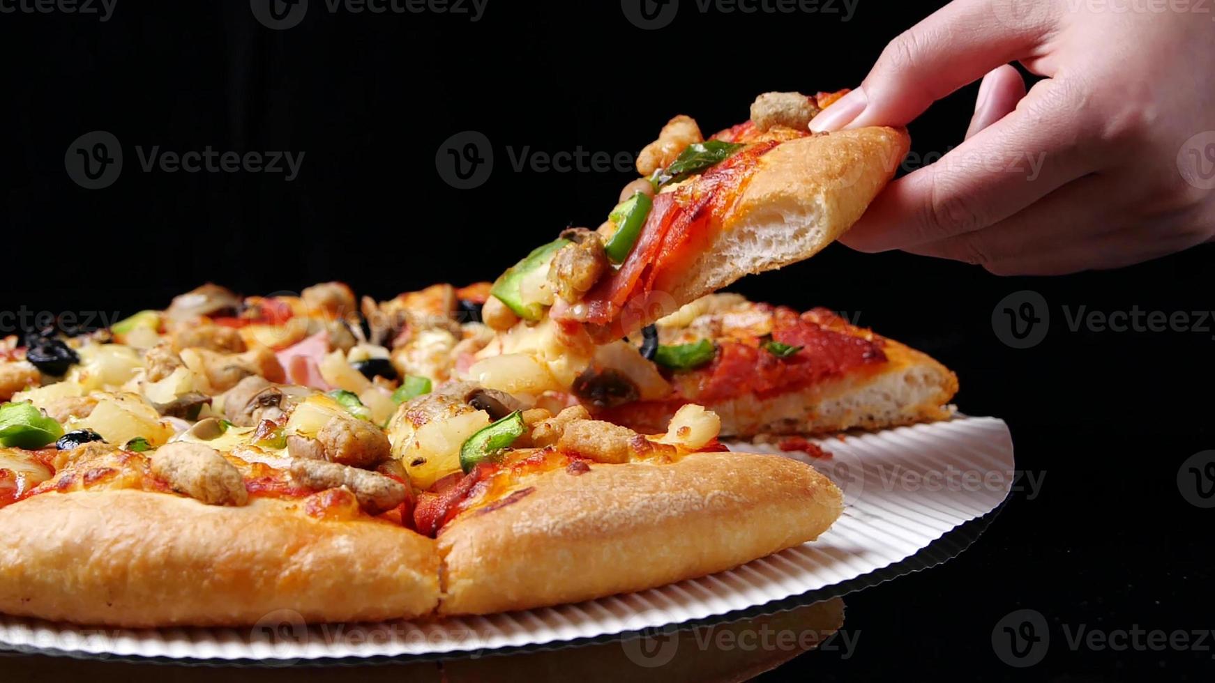 classic pizza with cheese on the table in a cafe on a wooden stand with a cut triangular piece and a pizza knife photo