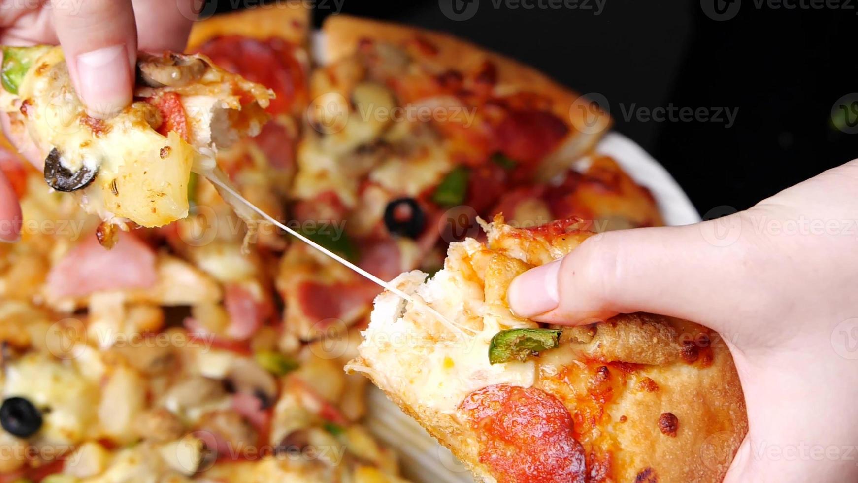 classic pizza with cheese on the table in a cafe on a wooden stand with a cut triangular piece and a pizza knife photo