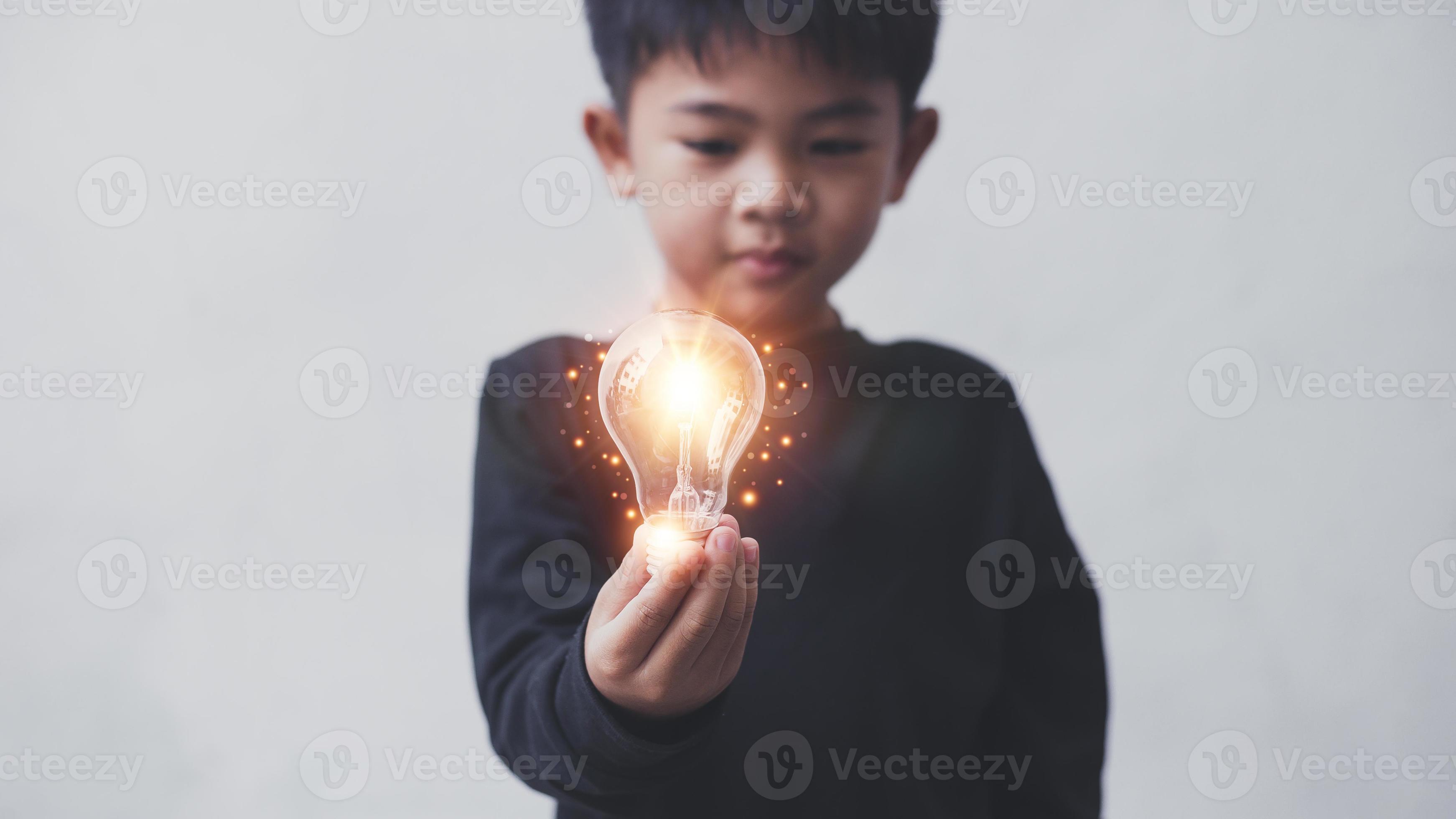Four year old boy holding light bulbs, Innovation. Hands holding light