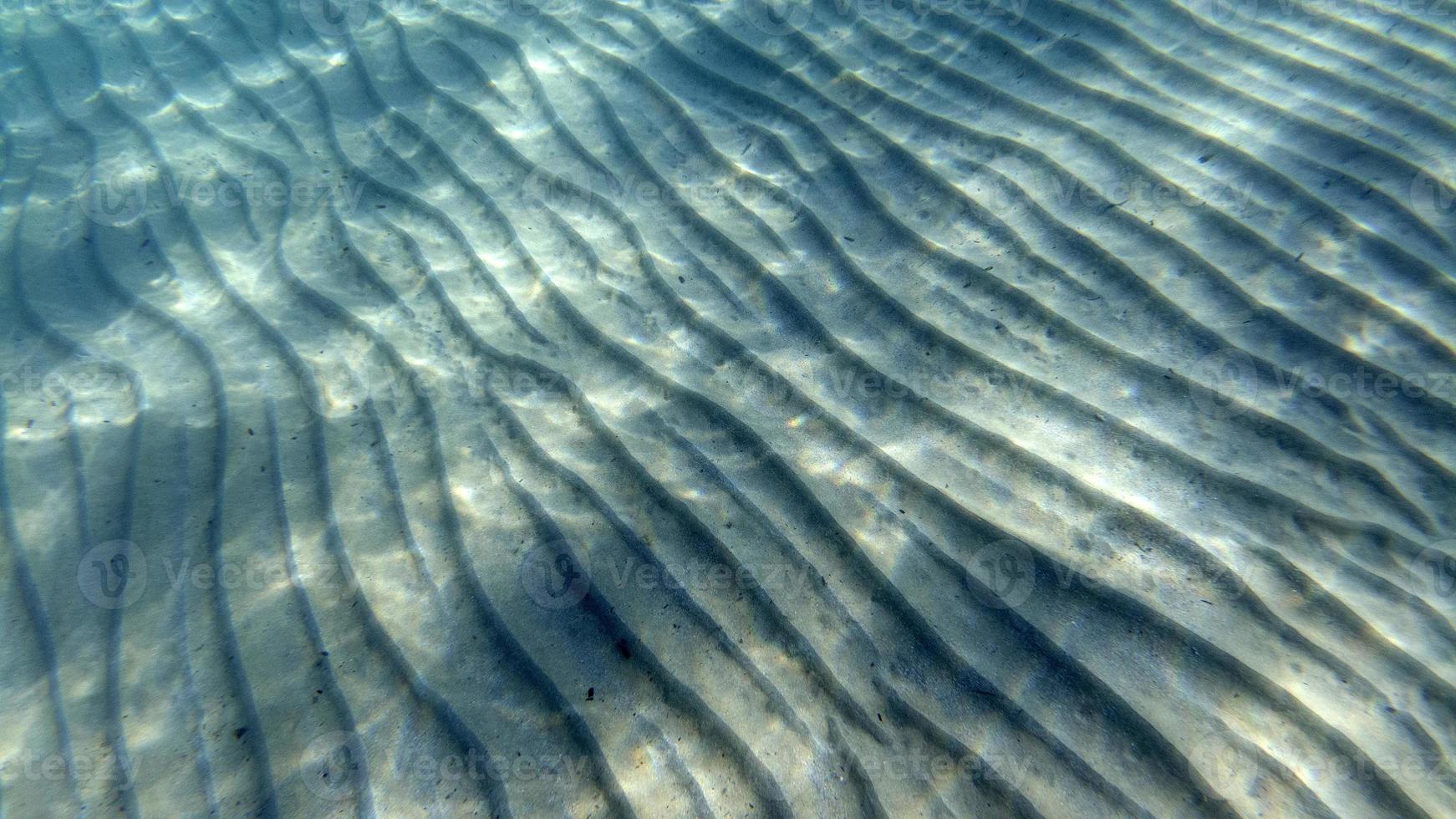 sand bottom underwater swimming in turquoise lagoon photo