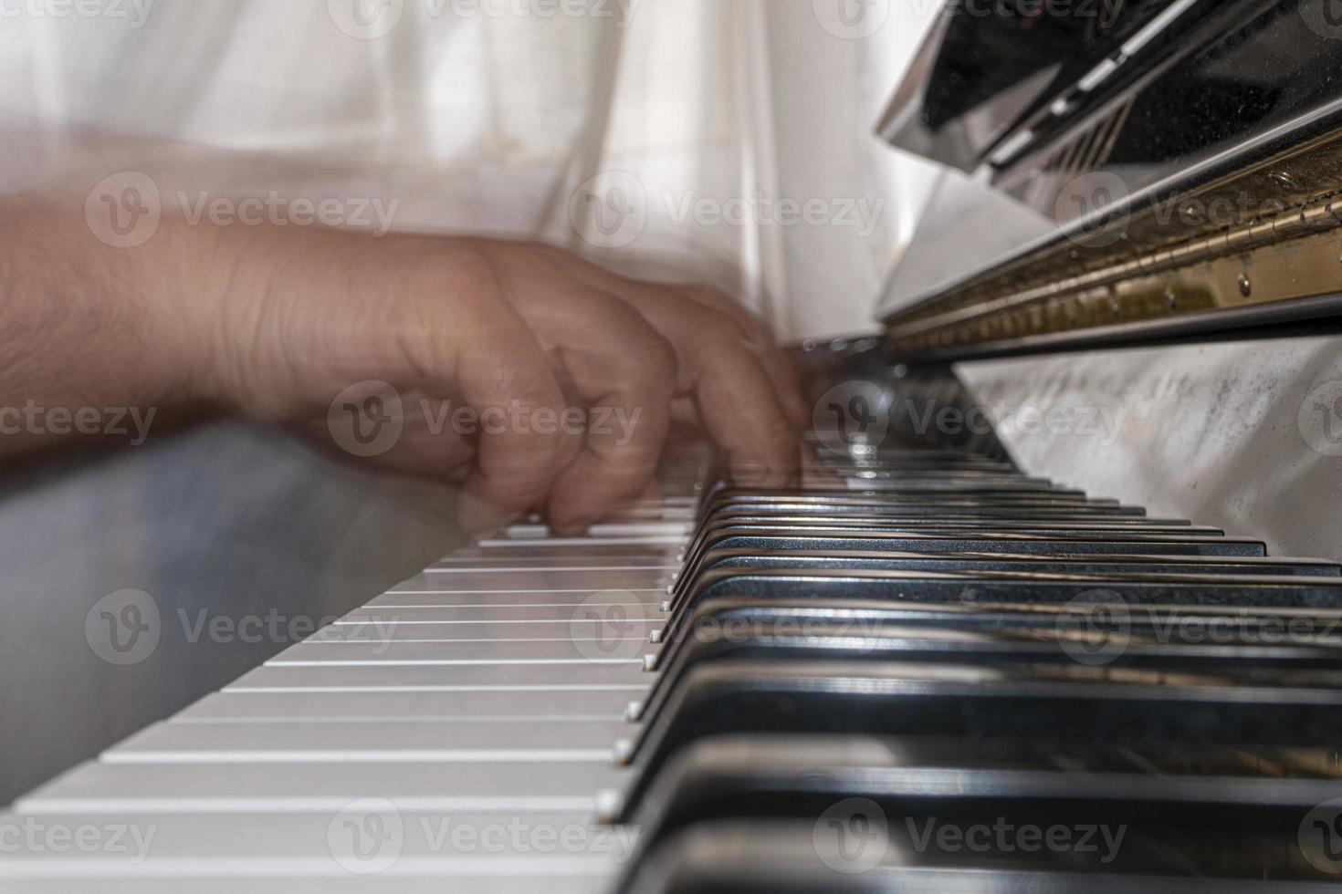 Hands playing piano while moving photo