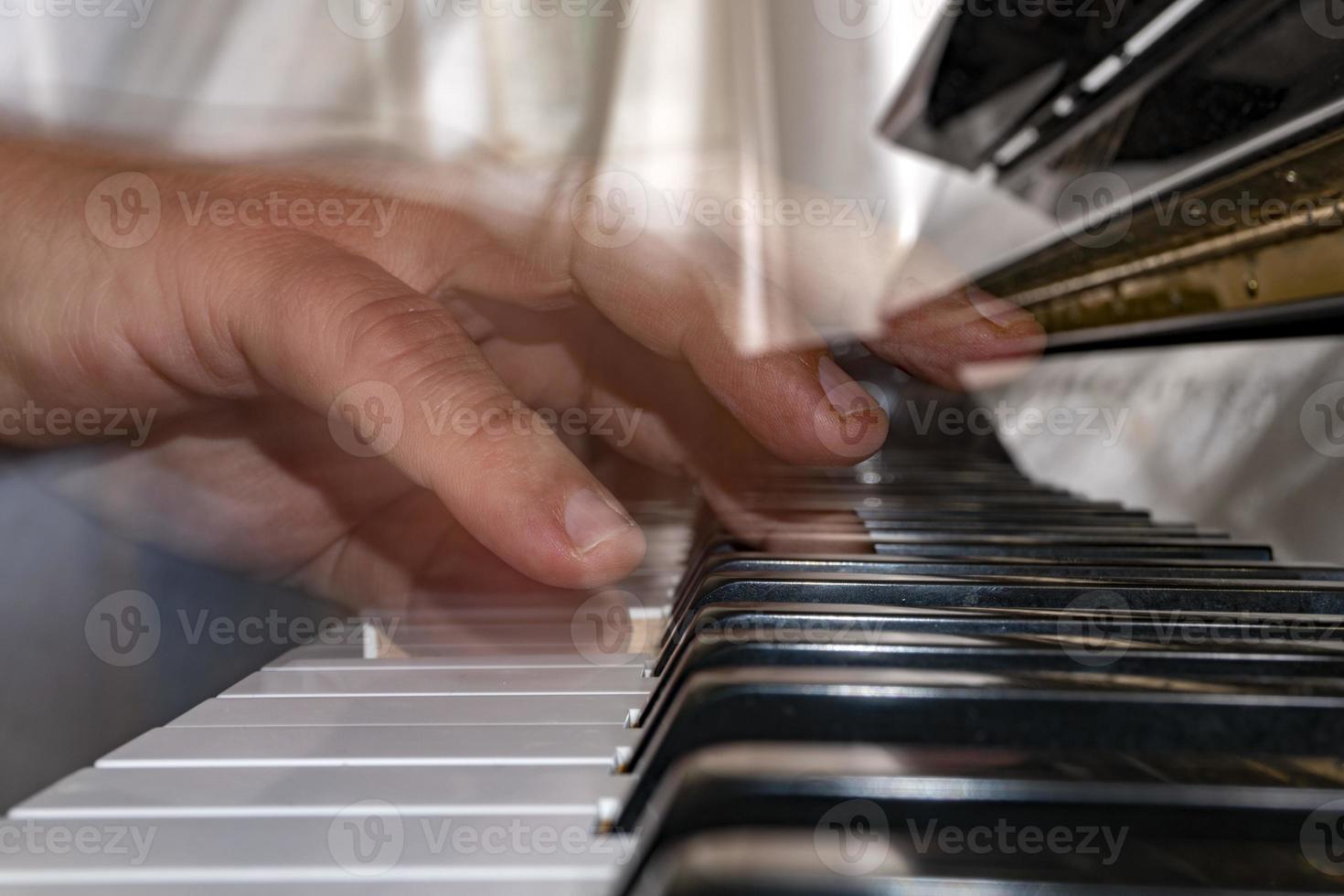 Hands playing piano while moving photo