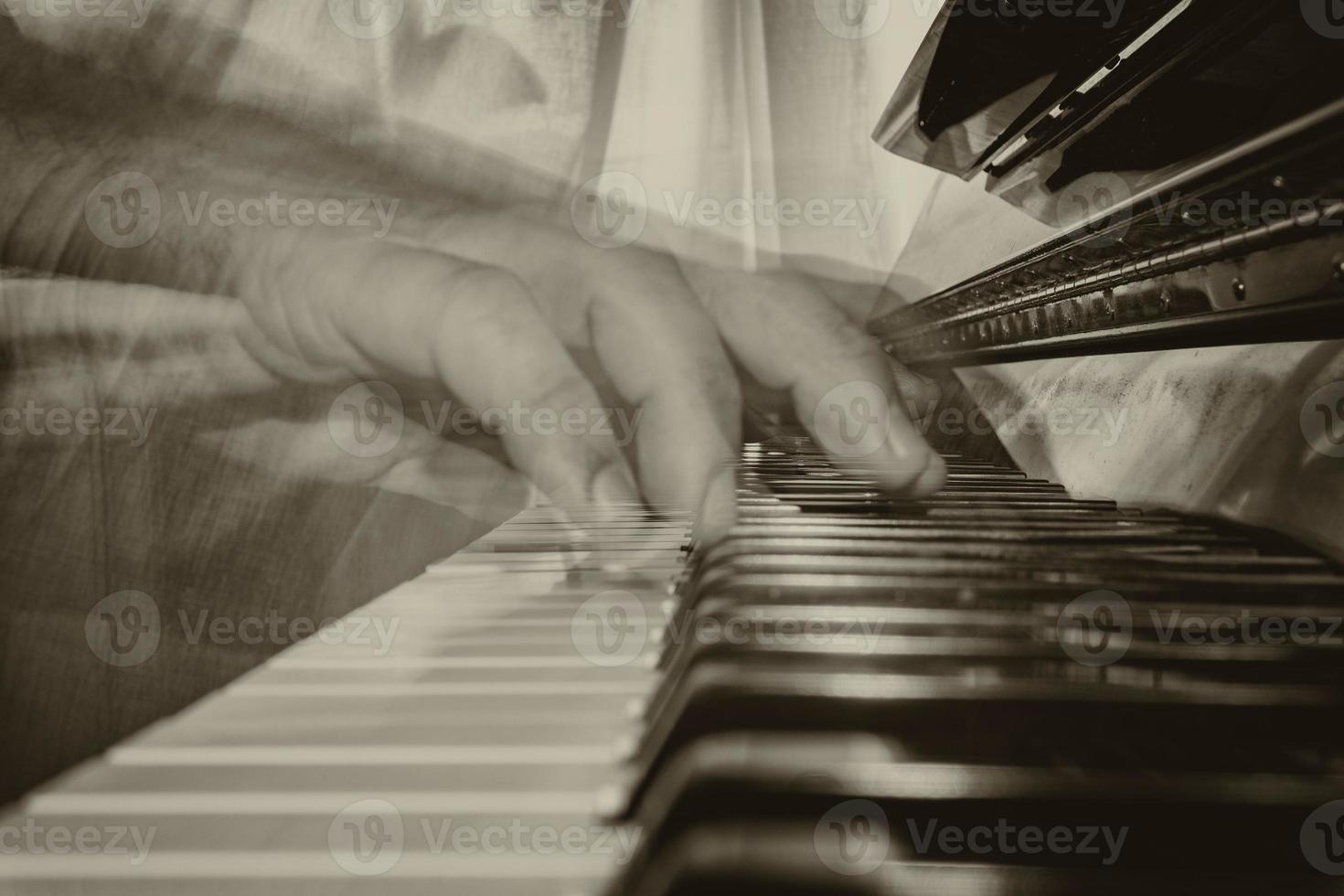 Hands playing piano while moving in sepia photo