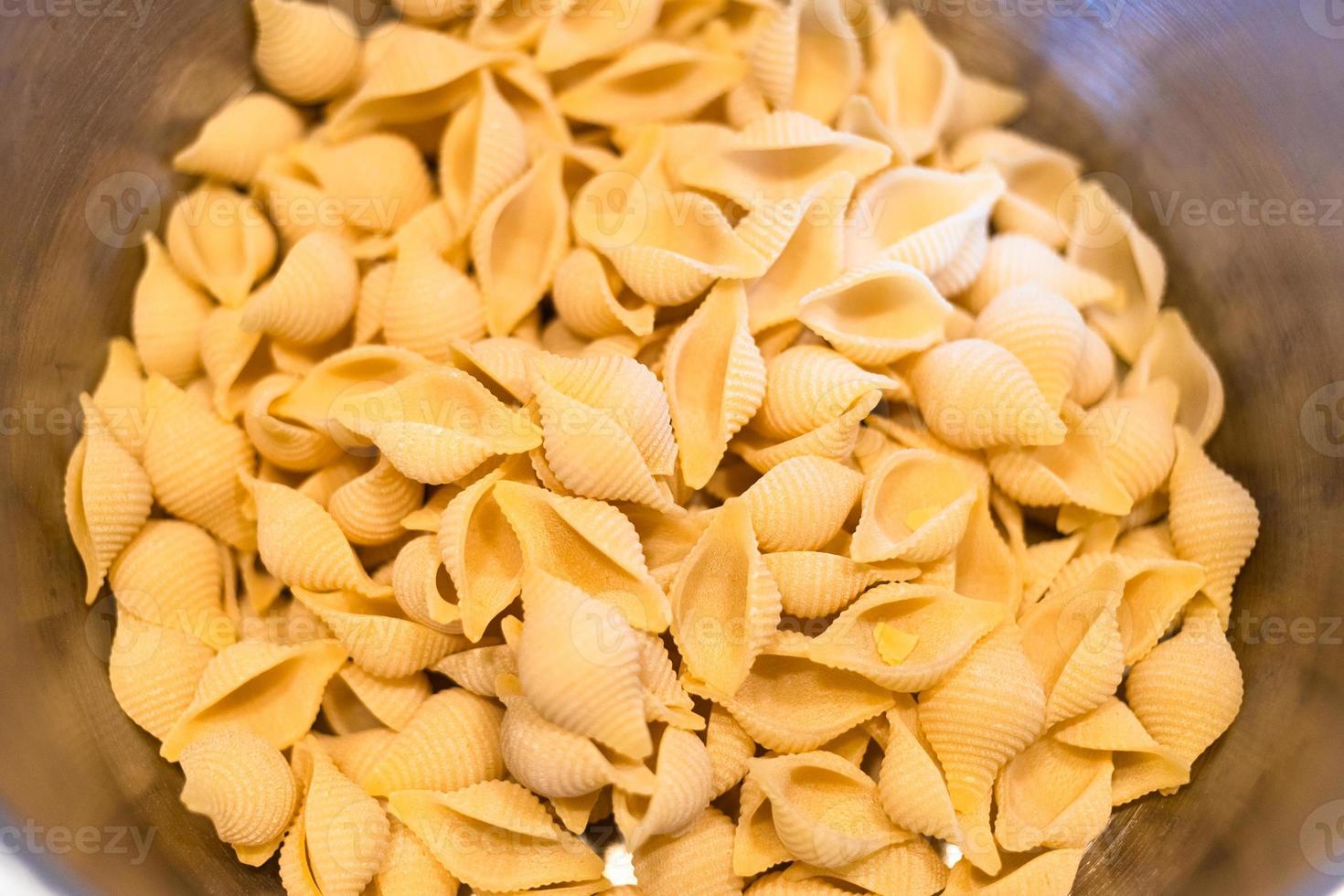 uncooked conchiglie rigate pasta in saucepan photo