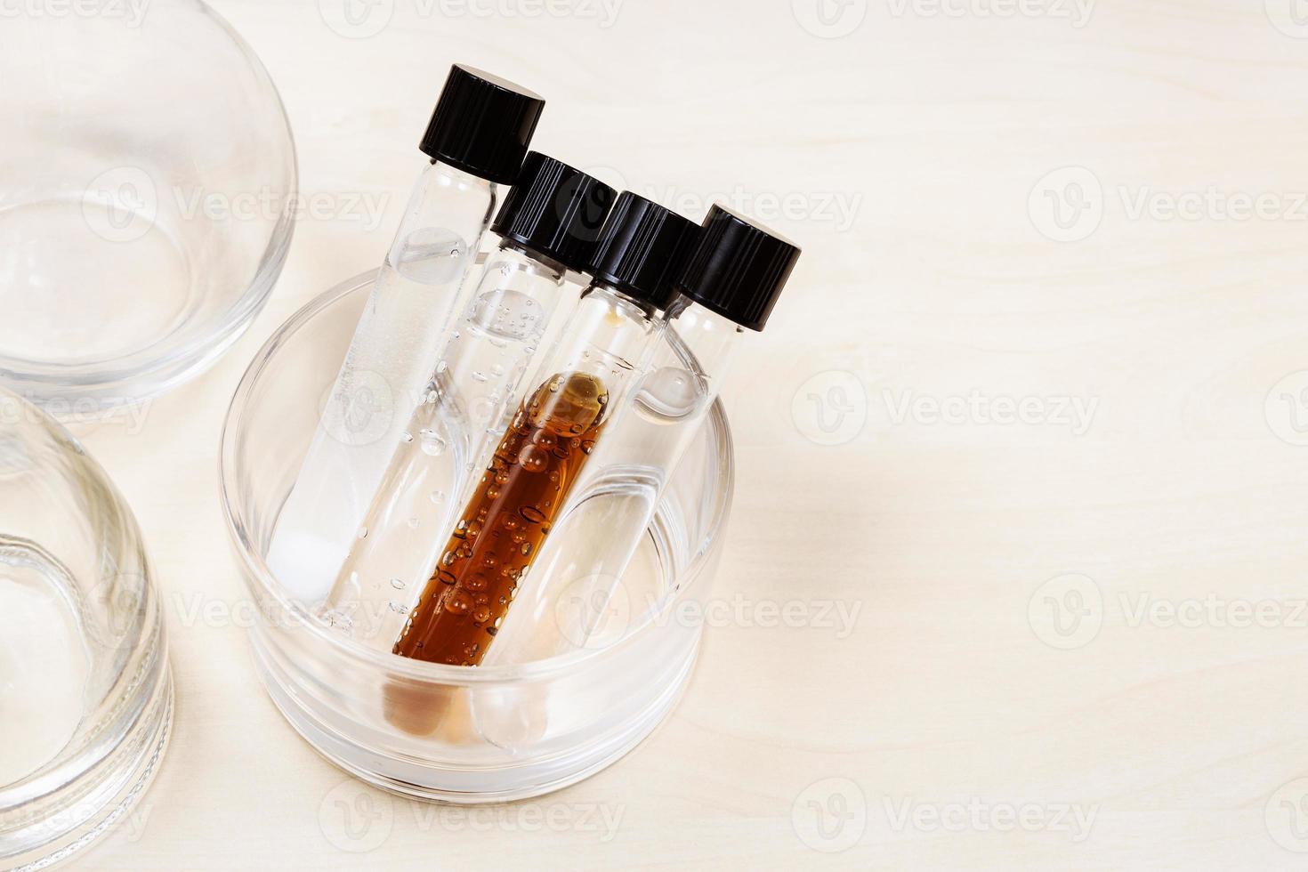 test tubes with liquids near flasks on light desk photo