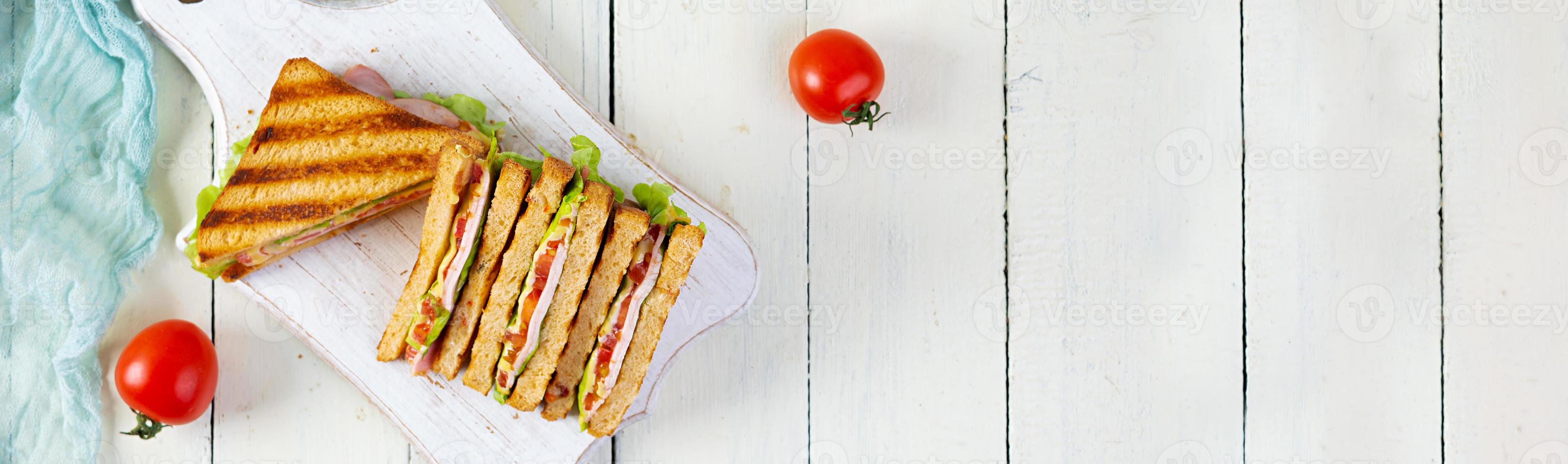 Club sandwich with ham, tomato, green and cheese. Grilled panini. Top view photo