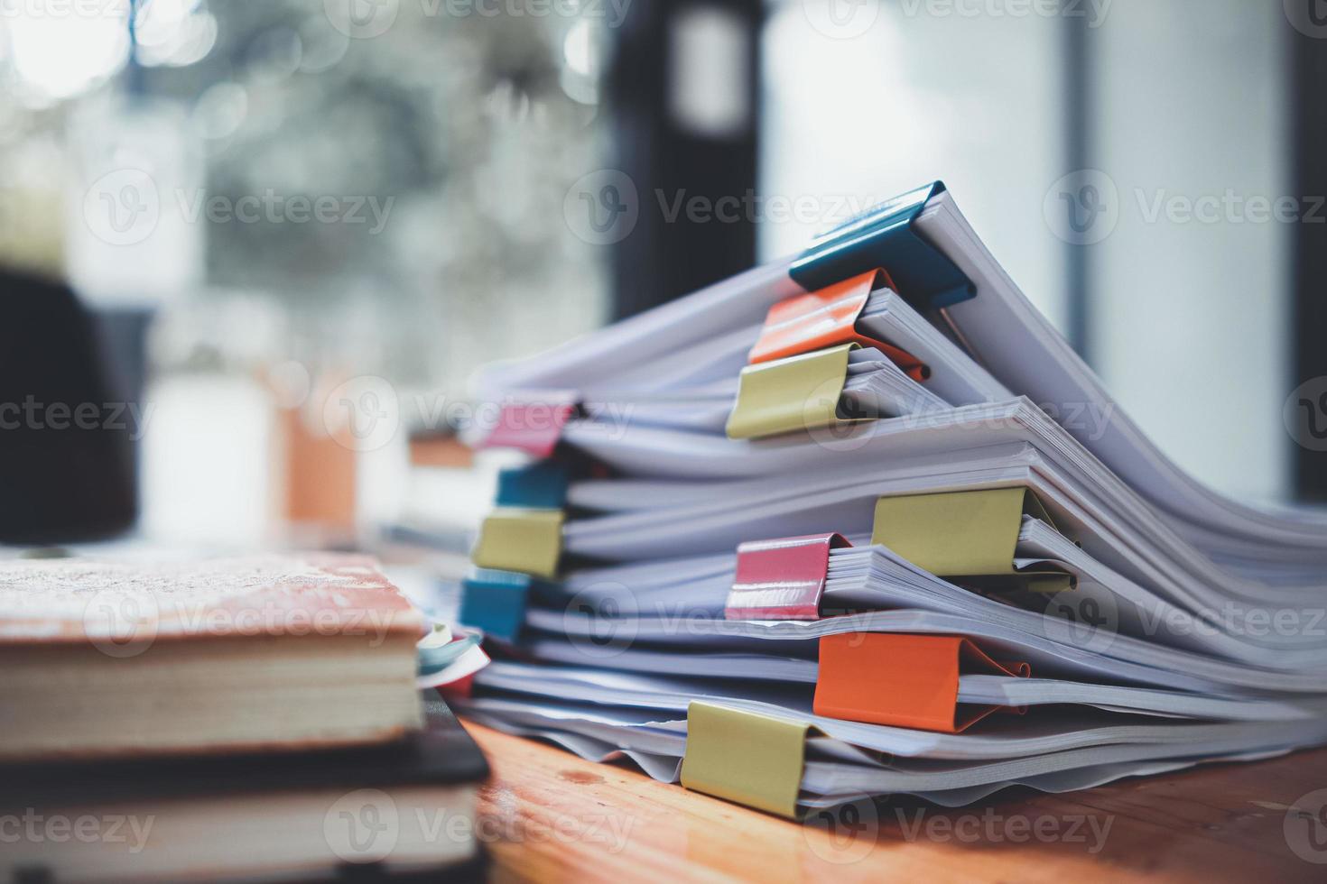 The stacks of documents lying on the desk are waiting to be verified before being sent to the Board of Directors to use the correct information before meeting with businessmen and investors. photo