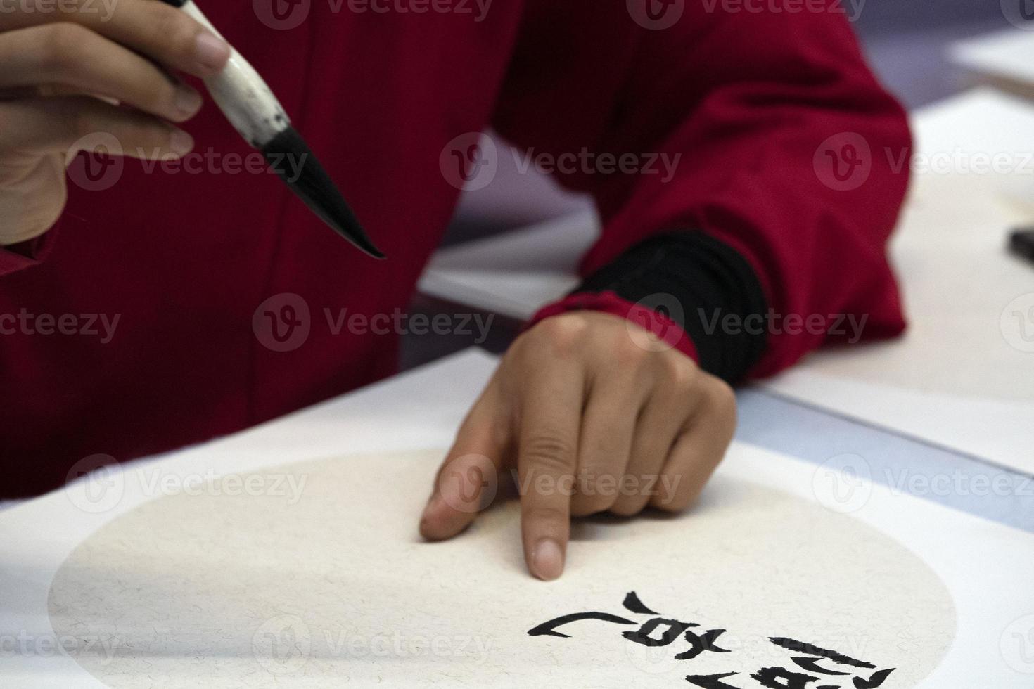 japanese woman writing name Elisabeth in ideograms with brush photo