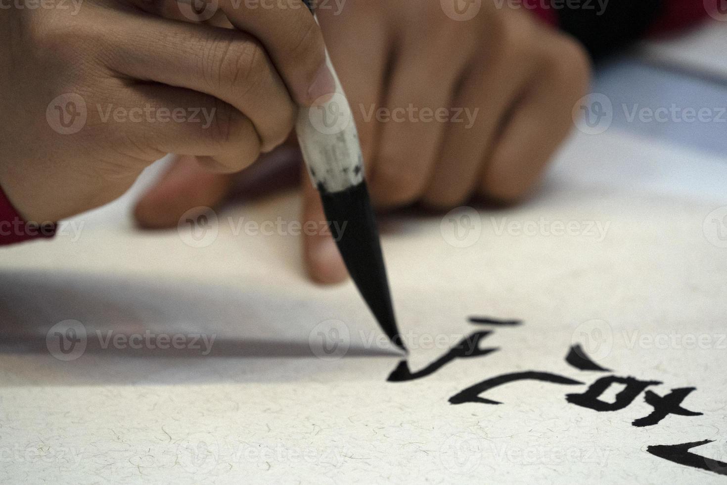 Japanese woman writing name Elisabeth in ideograms with brush photo