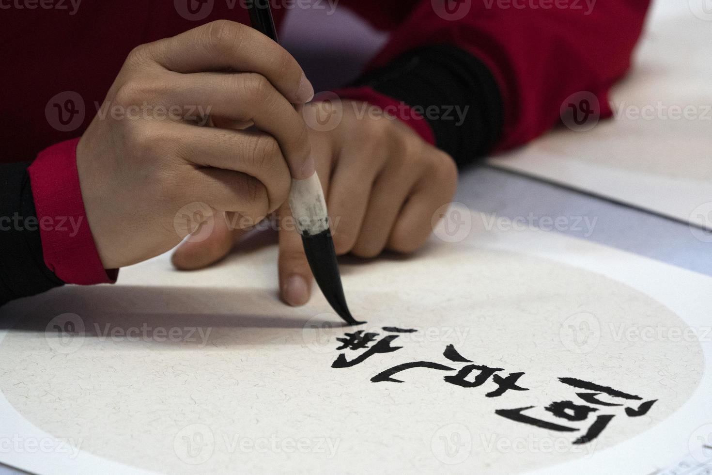 Japanese woman writing name Elisabeth in ideograms with brush photo