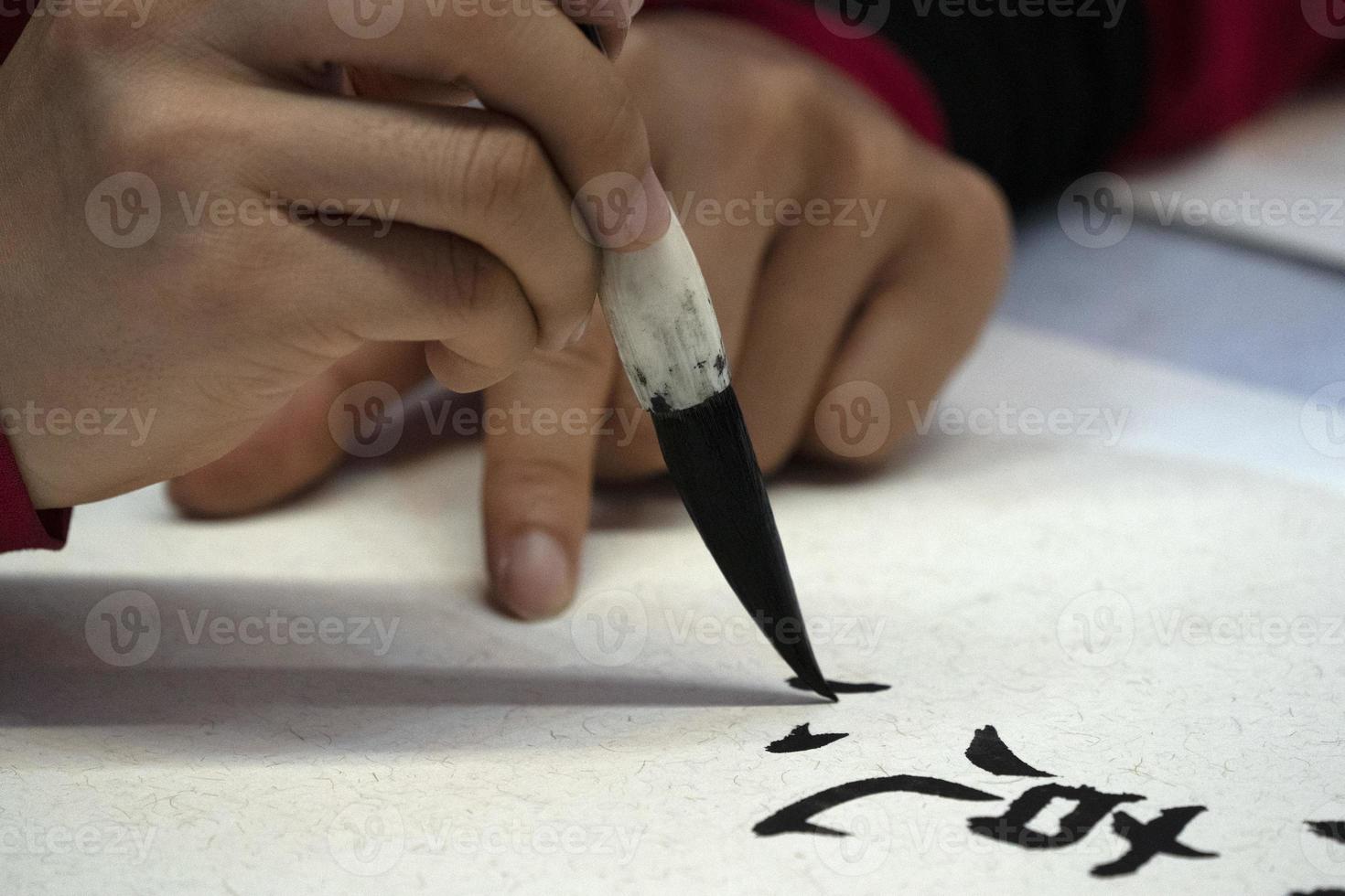 japanese woman writing name Elisabeth in ideograms with brush photo