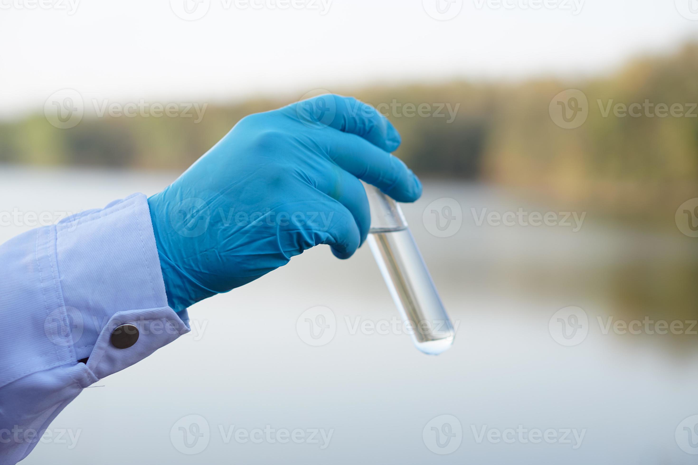 Closeup researcher hands wears blue gloves holds test glass tube that
