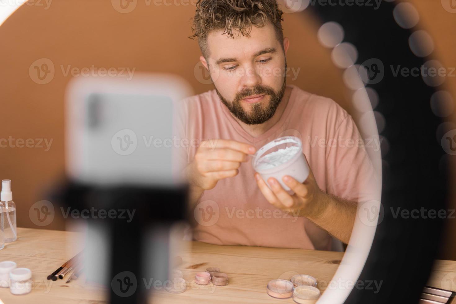 Man make up vlogger recording broadcast about cosmetics and tutorials for make-up artist photo
