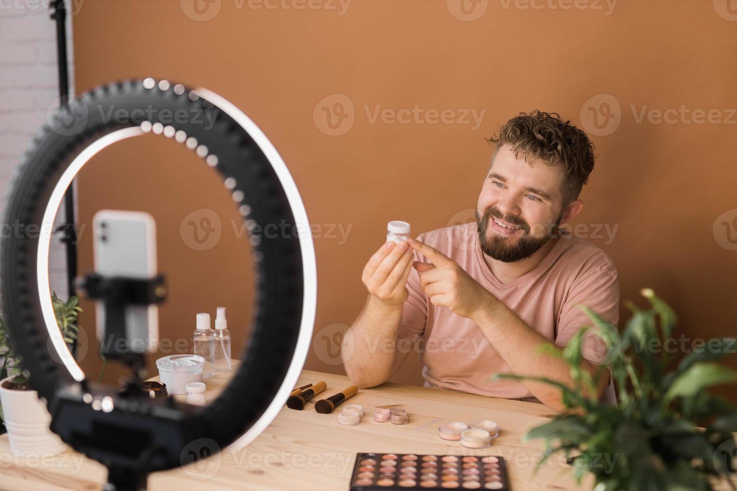 Portrait bearded man making vlog review cosmetics product and channel recording video make up tutorial making at home - Online influencer guy and social media market live steaming concept photo