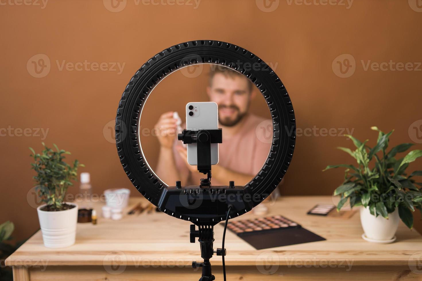 Portrait bearded man making vlog review cosmetics product and channel recording video make up tutorial making at home - Online influencer guy and social media market live steaming concept photo