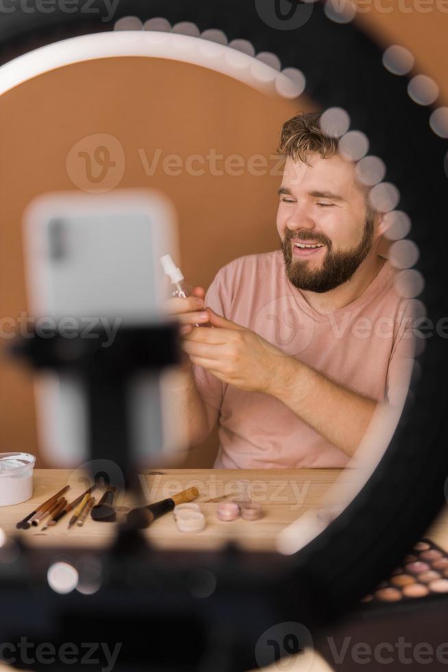 Man make up vlogger recording broadcast about cosmetics and tutorials for make-up artist photo
