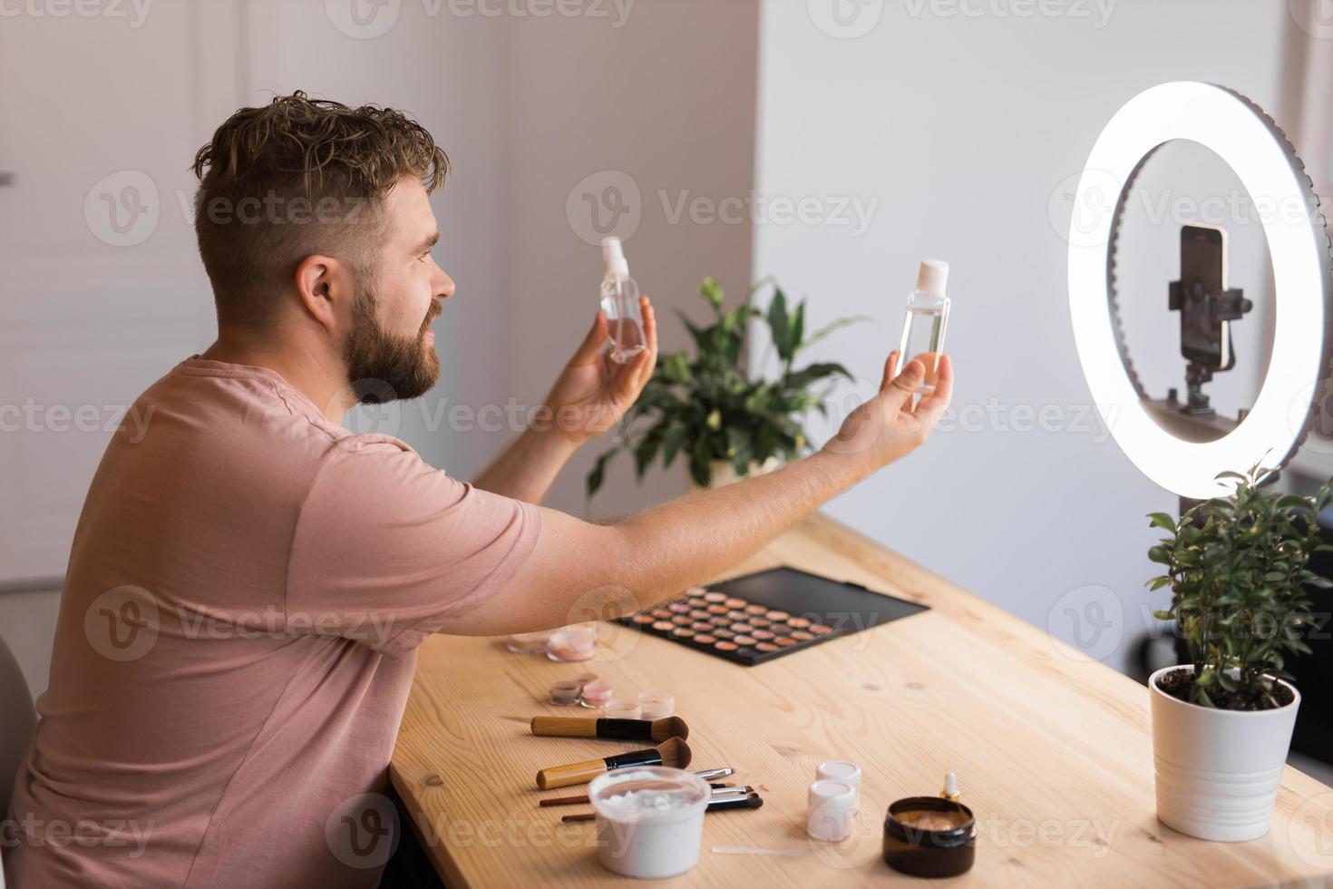 Man make up vlogger recording broadcast about cosmetics and tutorials for make-up artist photo
