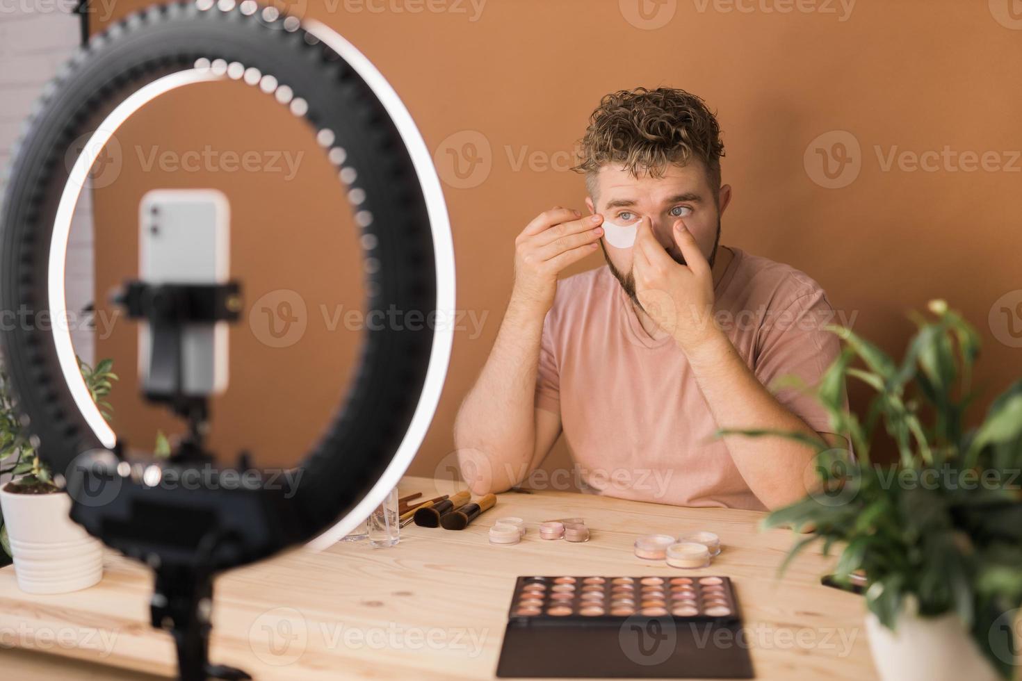 Man make up vlogger recording broadcast about cosmetics and tutorials for make-up artist photo