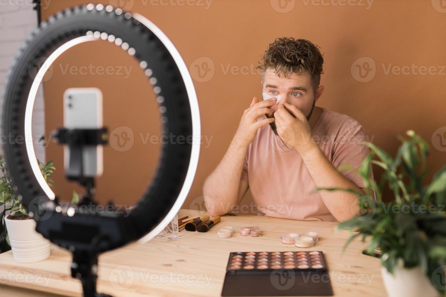 Portrait bearded man making vlog review cosmetics product and channel recording video make up tutorial making at home - Online influencer guy and social media market live steaming concept photo