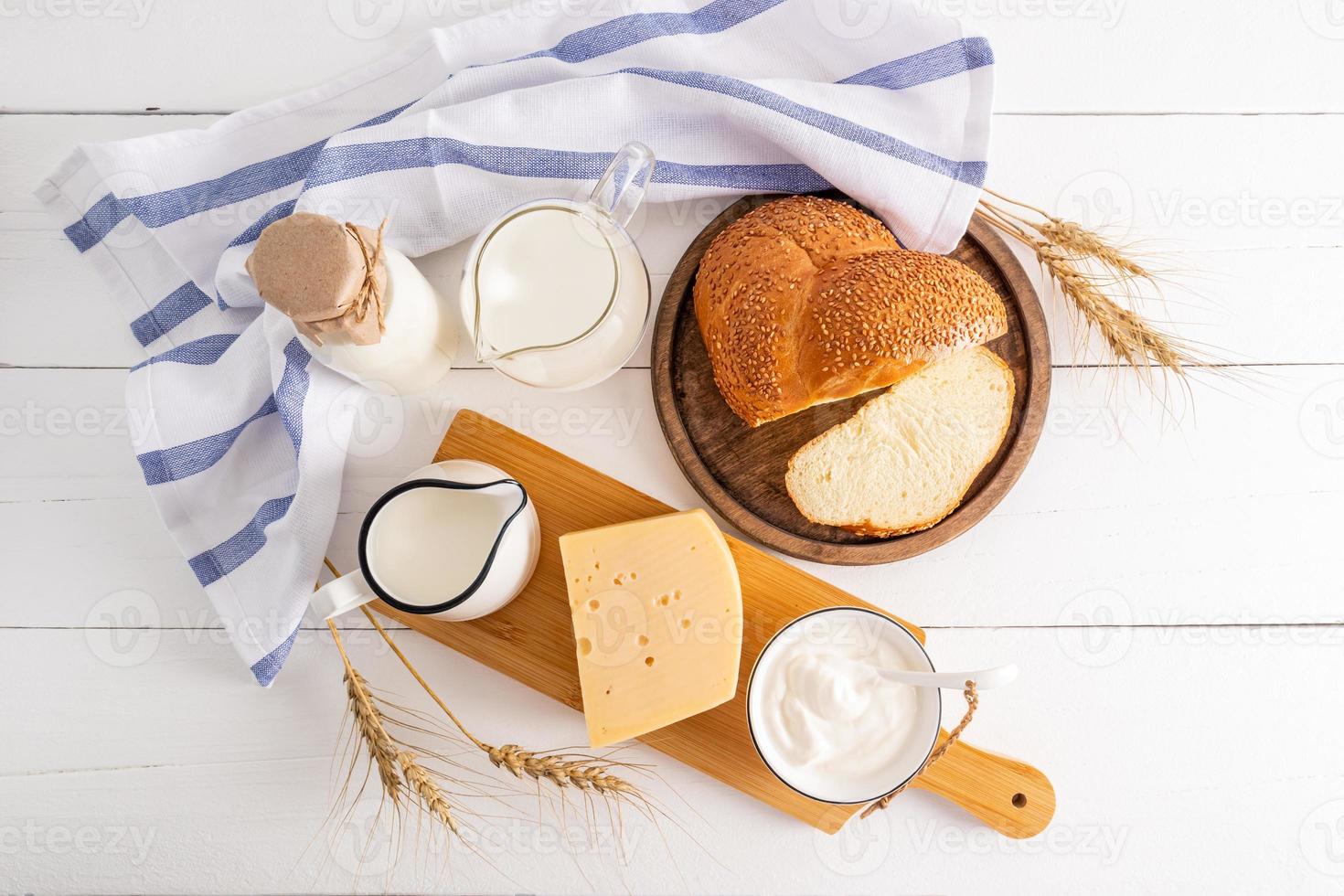 top view of the traditional treats for the Jewish holiday of Shavuot on a white wooden table. festive spring background. photo