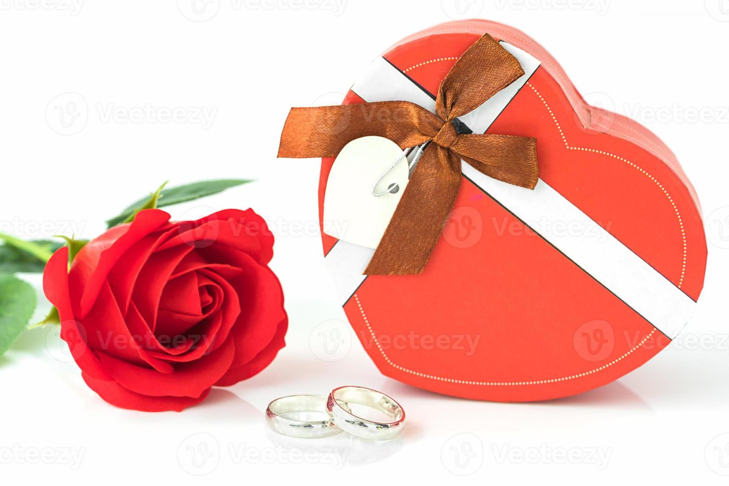 Red rose and heart-shaped box on white photo