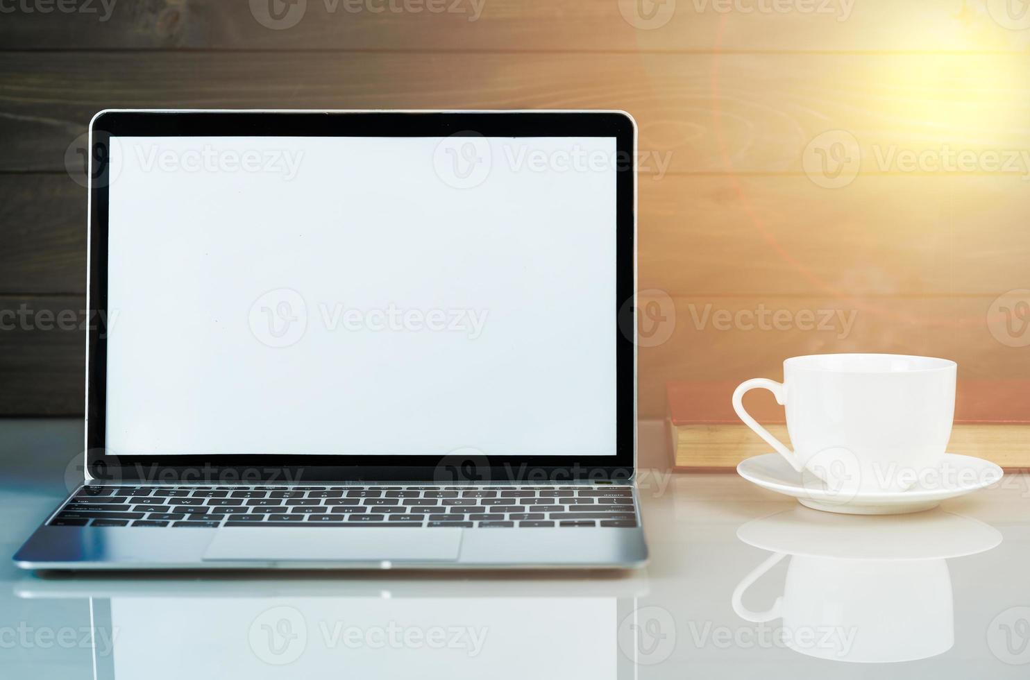 Laptop mockup and coffee cup with wood background on the work table photo