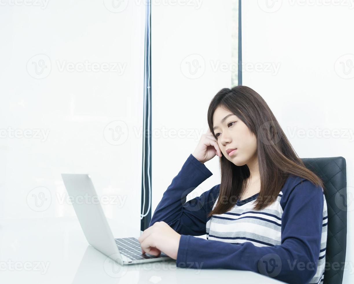 Young female student  sitting in living room and learning online photo