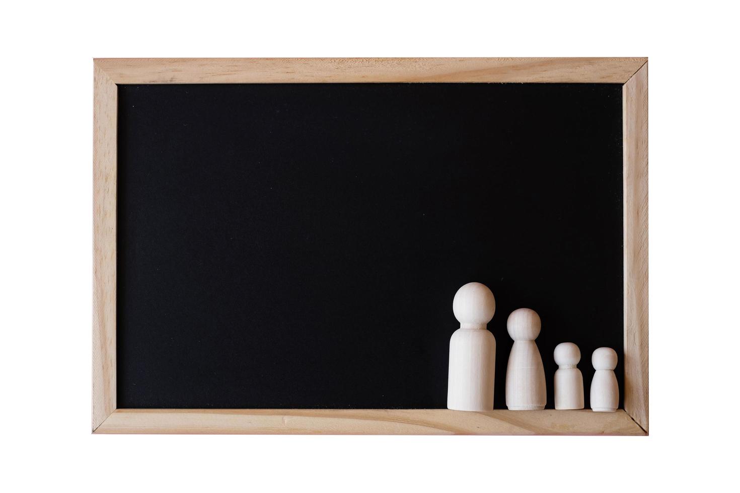 Wooden figurines of family father, mother and children on the black board on white background.  copy space for text. photo